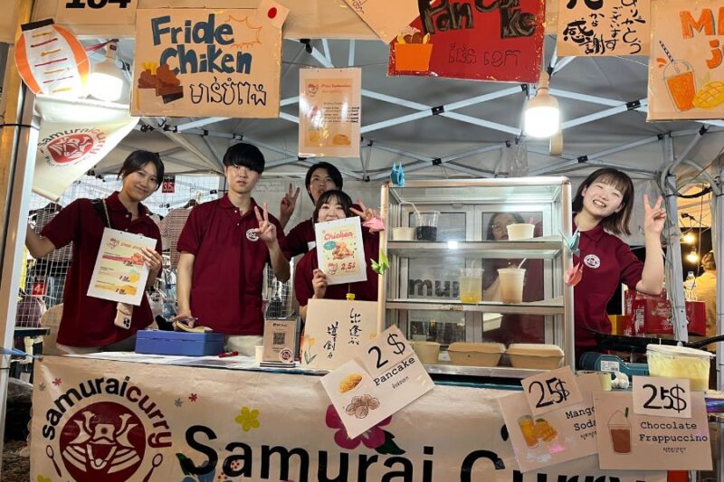 サムライカレーの学生が露店でフライドチキンを販売する様子
