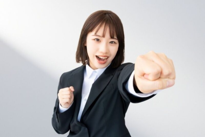 スーツの女性がガッツポーズする様子