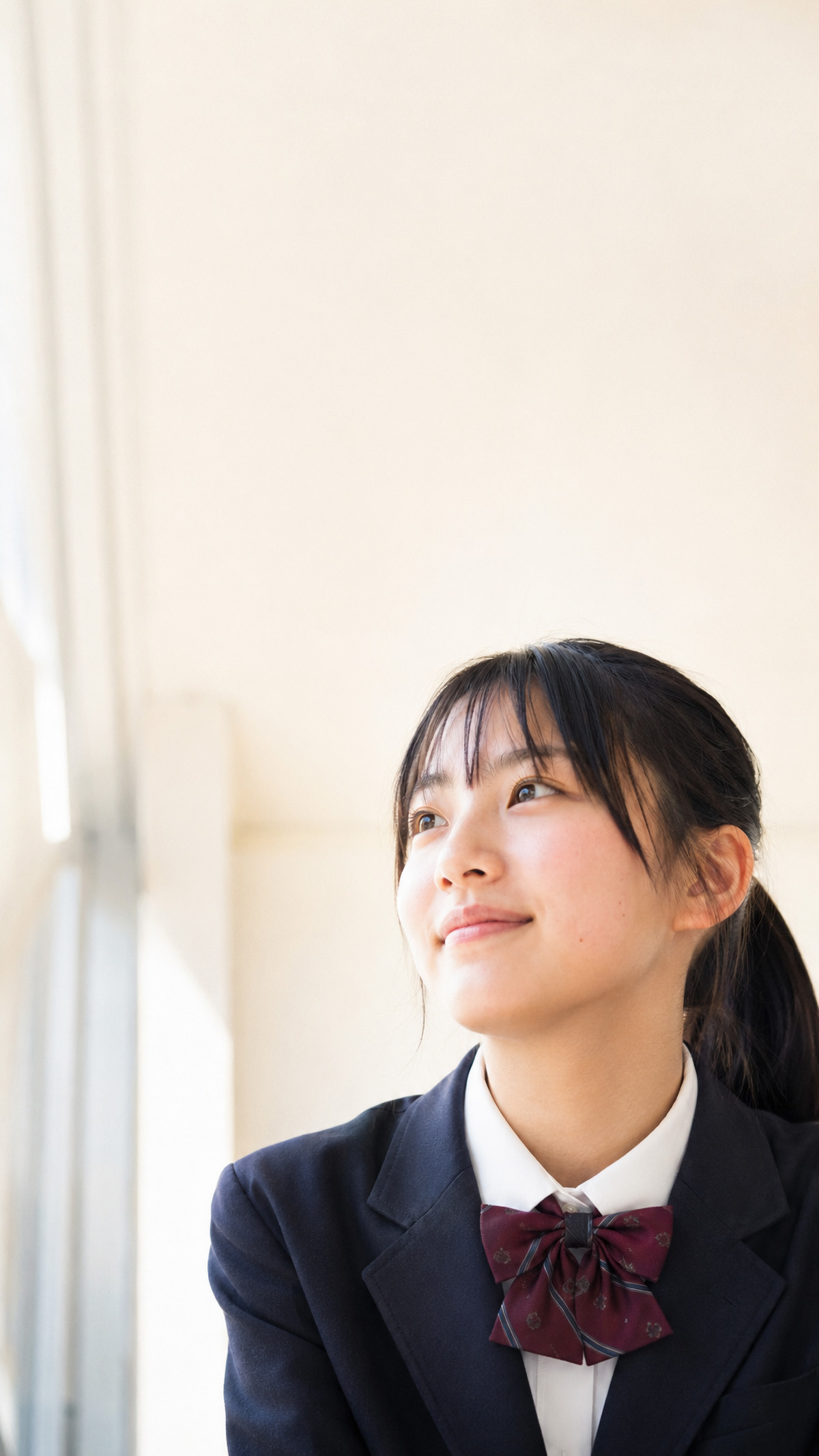 校舎の通路で、前を見上げて将来を思い描く制服姿の高校生